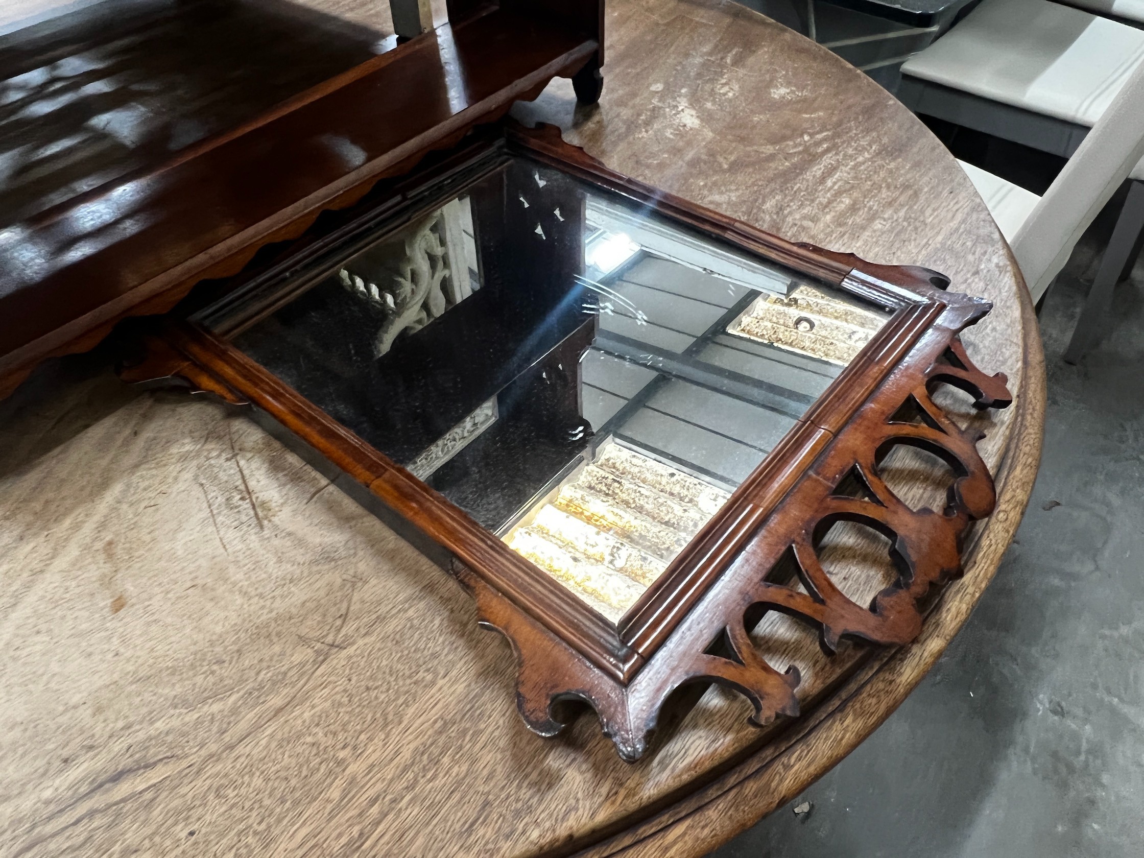 A Victorian mahogany three tier wall bracket, width 61cm height 63cm, and a small walnut fret cut wall mirror, height 52cm